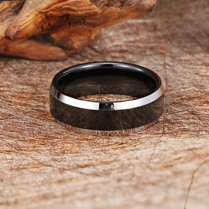 Modern black and silver tungsten ring shown from a 45-degree angle on a rustic background