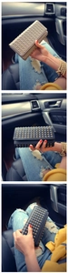 Detail of studded leather wallets in black and grey shown in a stylish car interior
