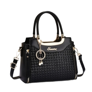 Elegante borsa a mano da donna in pelle intrecciata nera con dettagli dorati e perle