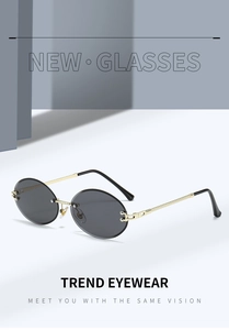 Detailed close-up of rimless oval sunglasses with grey lenses and textured gold metal temples