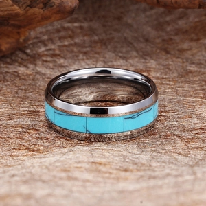 Flat silver tungsten steel ring with turquoise inlay on a brown textured background