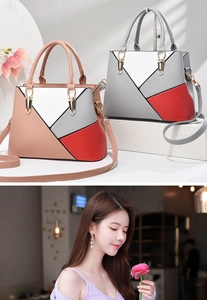 Detail of color-block leather handbag featuring gold metal rings and top handle straps