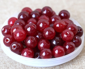 Macro shot of polished dark red round agate beads stacked for DIY jewelry making