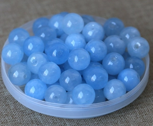 Macro detail of sky blue round glass beads with holes for DIY jewelry making