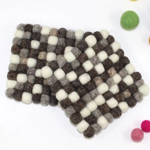 Handmade square wool felt ball coasters in checkered brown and grey tones on white background