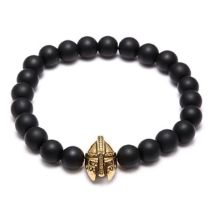 Macro detail of spartan helmet charm with pave setting on black matte bead bracelet