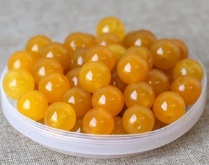 Macro shot of polished yellow natural jade beads for DIY jewelry and handicraft making