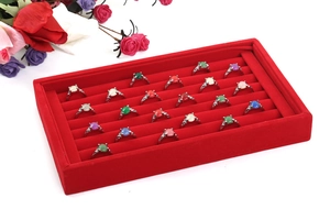 Macro view of red velvet ring display tray filled with silver colorful gemstone rings