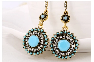 Macro shot of vintage bohemian earrings with turquoise stones and white crystals
