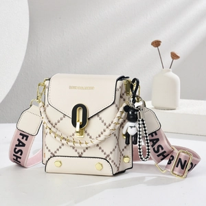 Détail du petit sac bandoulière avec motif à losanges et pendentif ours