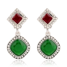 Detail showing vintage silver earrings with red and green stones and white crystals