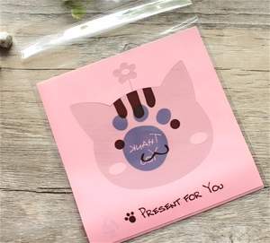 Macro detail of cartoon cat gift bag with translucent window and Thank You card