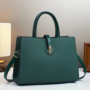 Detail of dark green woven handbag featuring golden hardware buckles and a structured handle