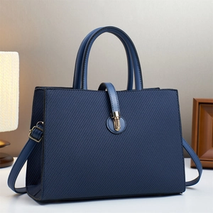 Fashionable dark blue striped tote bag with gold metal clasp and adjustable strap