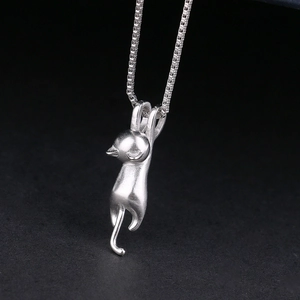 Macro shot of S925 sterling silver playful cat pendant with matte texture on box chain
