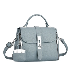 Light blue-gray pebbled leather trapezoid handbag with silver lock and top handle
