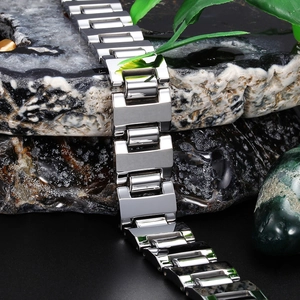 Polished silver tungsten steel men's bracelet with H-link design on volcanic rock background