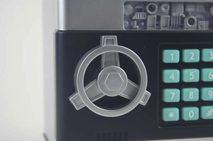 Detail of ATM piggy bank showing numeric silicone keys and silver rotating handle