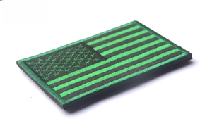 Close-up of tactical USA flag patch with green and black embroidery and hook backing