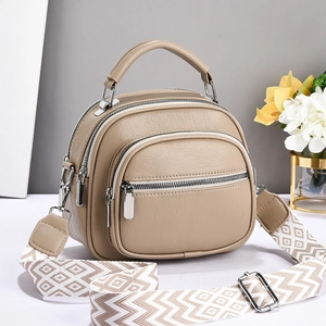 Khaki pebbled leather shoulder bag with multiple zippers and patterned woven strap