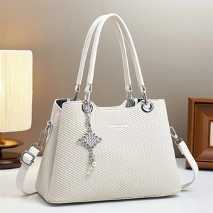 White woven leather handbag with pearl charm and silver hardware shown in lifestyle setting