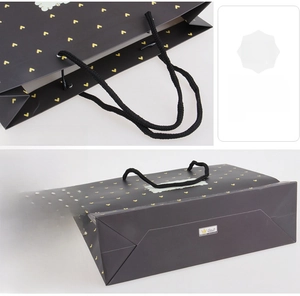 Detail of sturdy braided handle and reinforced bottom on black heart print gift bag