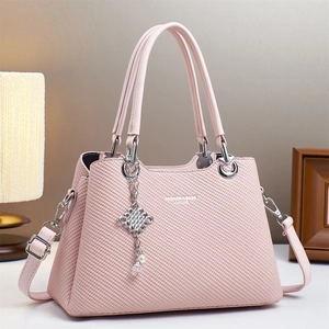 Pink macaron fashion handbag with textured finish and elegant pearl charm detail