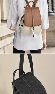 Detail of lychee textured faux leather backpacks in brown and black with metal charms
