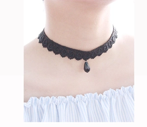 Detail of a black lace choker necklace featuring a teardrop pendant on a model