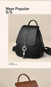 Detail view of smooth lychee pattern leather backpack with metal smiley face charm