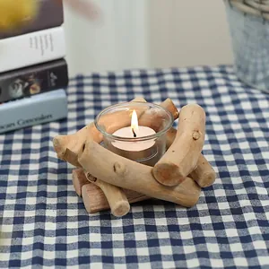 Handcrafted driftwood pillar candle holder with clear glass insert on checkered tablecloth