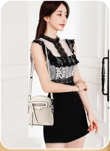 Detail of ivory pebble leather mini crossbody bag featuring tassels and rivets on model