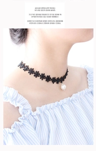 Close-up of black lace floral choker necklace featuring a white faux pearl pendant