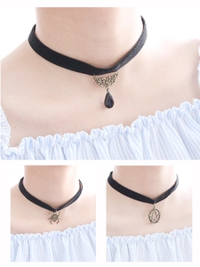 Macro view of gothic velvet choker set featuring spider, pentagram, and teardrop charms