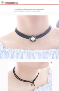 Detail of black velvet pearl choker and double-string bell necklace on model