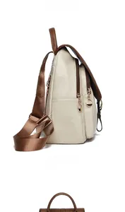 Close-up of contrast cream and brown faux leather backpack with multi-zipper pockets