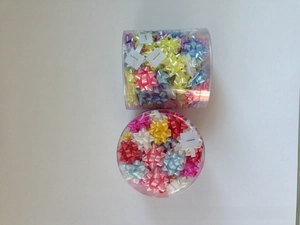Bulk set of 1-inch mini metallic star bows in assorted colors inside clear tube packaging
