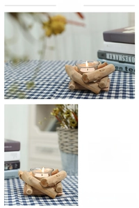 Close-up of a rustic driftwood candle holder with a glass cup and lit white tea light