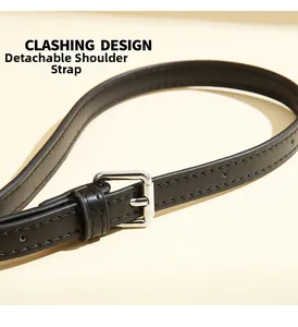 Detail of adjustable black leather strap with silver metal buckle and stitching