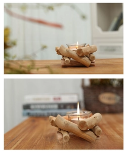 Close-up of a rustic driftwood candle holder with a glass cup and lit candle
