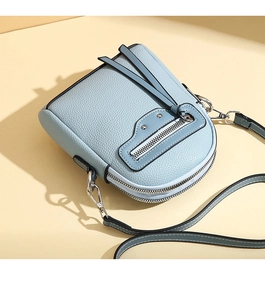 Detail view of light blue lychee pattern crossbody bag with fringe and silver studs