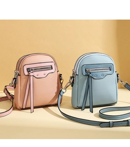 Detail of pink and light blue mini crossbody bags with lychee grain texture and tassels