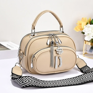 Chic beige lychee grain shoulder bag with wide strap and metallic charms detail