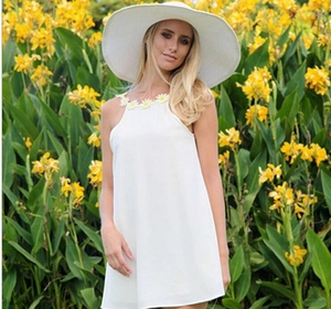 Weißes Neckholder-Kleid mit Gänseblümchen-Stickerei und Sommerhut im Freien