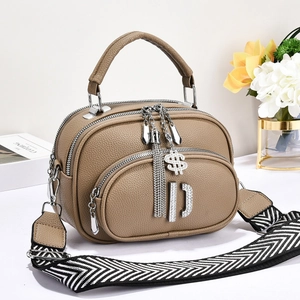 Close-up of khaki lychee grain leather bag with rhinestone pendants and woven strap