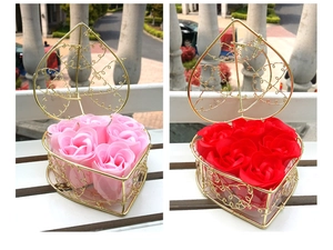 Detail of heart-shaped metal wire baskets filled with red and pink soap rose flowers