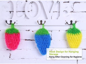 Three colorful strawberry dish sponges hanging on a hook for kitchen cleaning storage
