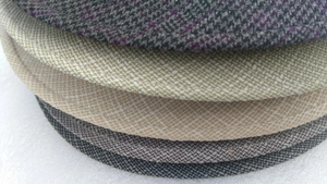 Detail of multi-color newsboy caps showing diverse fabric textures and woven patterns