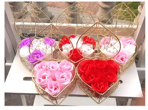 Detail of heart-shaped wire boxes with colorful soap roses in purple, white, and red