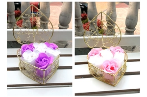 Detail of heart-shaped gold metal wire baskets containing six soap rose flowers